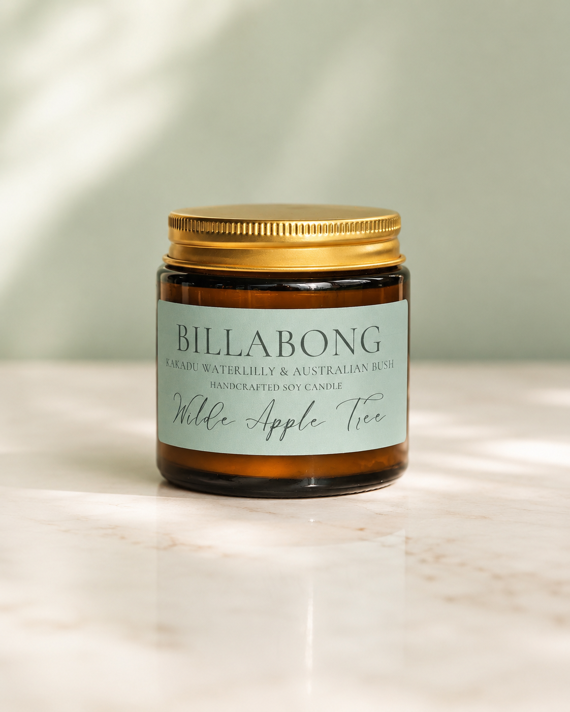 Wilde Apple Tree Billabong mini soy candle in amber glass jar with sage green label on marble surface, Kakadu waterlilly and Australian bush scent, handcrafted soy candle made in Australia