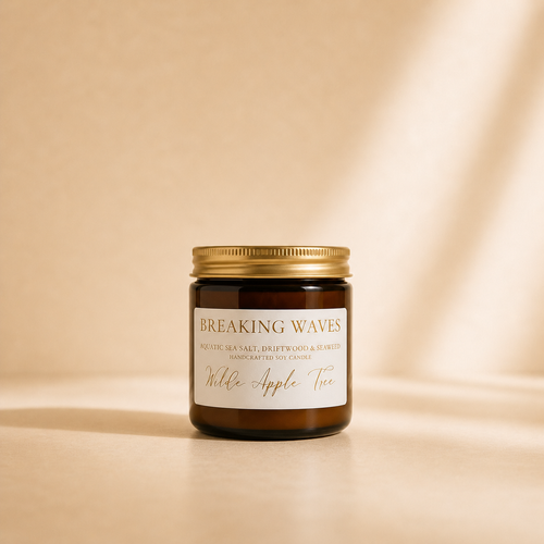 Wilde Apple Tree Breaking Waves mini soy candle in amber glass jar with gold lid, warm studio lighting with soft shadows, aquatic sea salt driftwood and seaweed scented handcrafted soy candle made in Australia