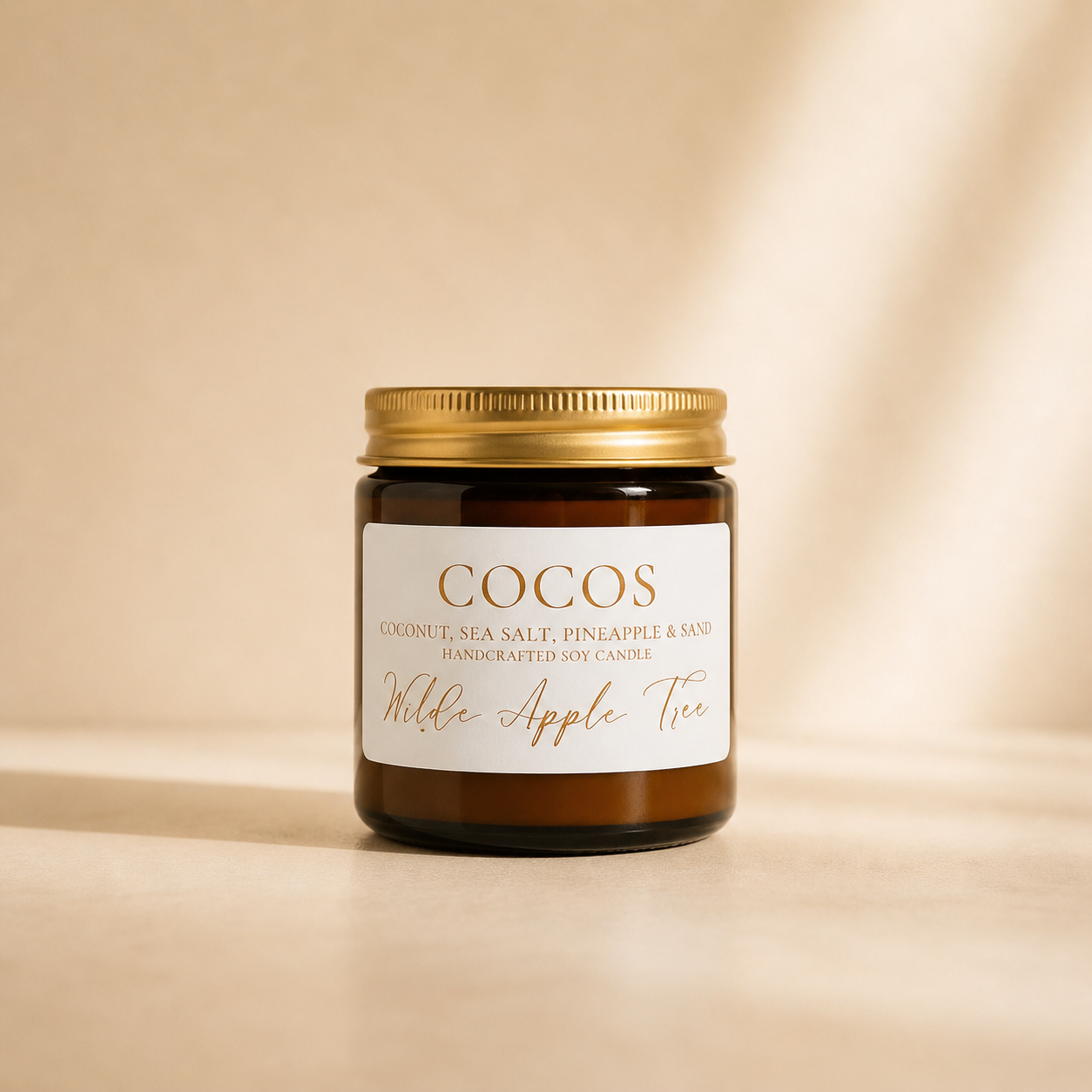 Wilde Apple Tree Cocos mini soy candle in amber glass jar with gold lid, warm studio lighting, coconut sea salt and pineapple scented handcrafted soy candle made in Australia