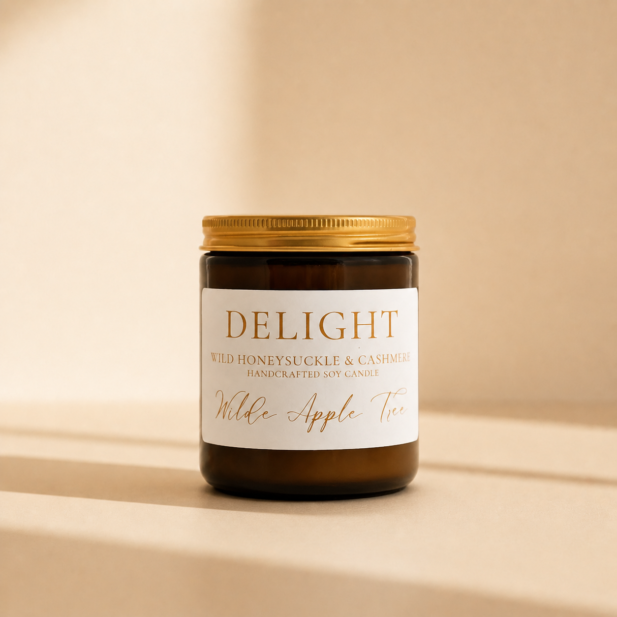 Wilde Apple Tree Delight medium soy candle in signature amber glass jar with gold lid on neutral background, wild honeysuckle and cashmere scented soy candle handcrafted in Australia