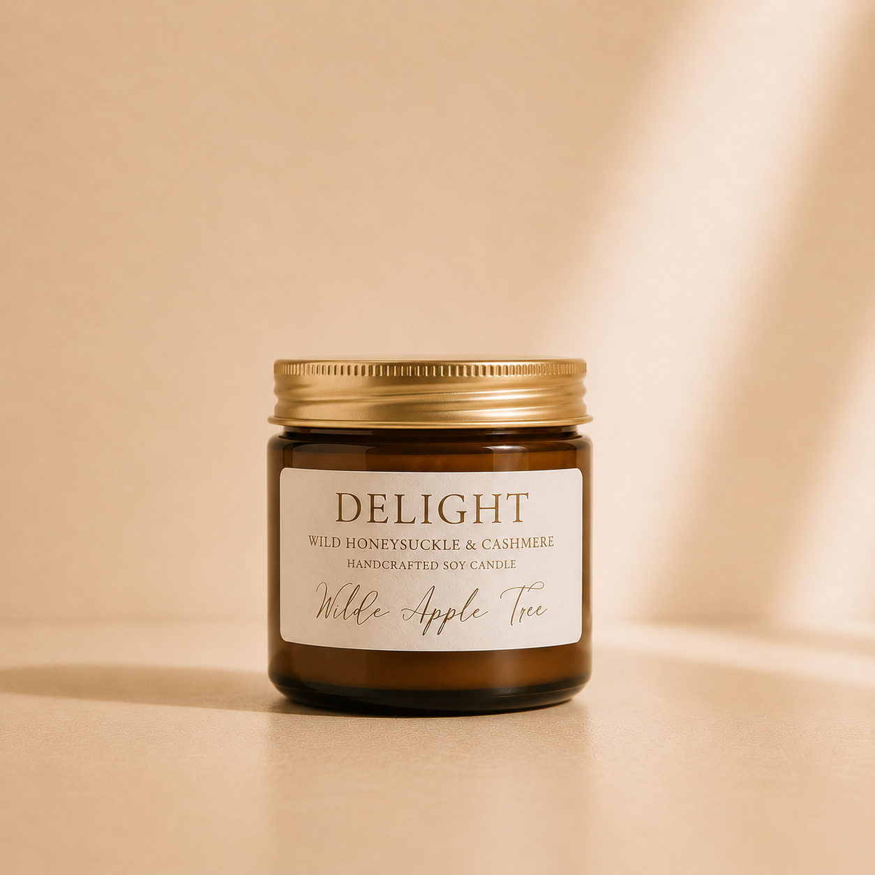 Wilde Apple Tree Delight mini soy candle in amber glass jar with gold lid, photographed in warm studio light, wild honeysuckle and cashmere handcrafted soy candle made in Australia