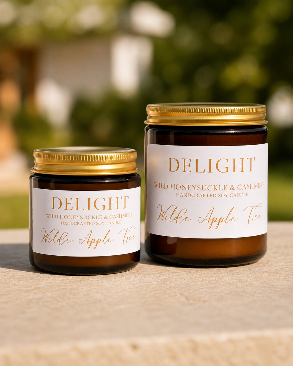 Wilde Apple Tree Delight handcrafted soy candles in mini and medium amber glass jars side by side outdoors, wild honeysuckle and cashmere scent, made in Australia