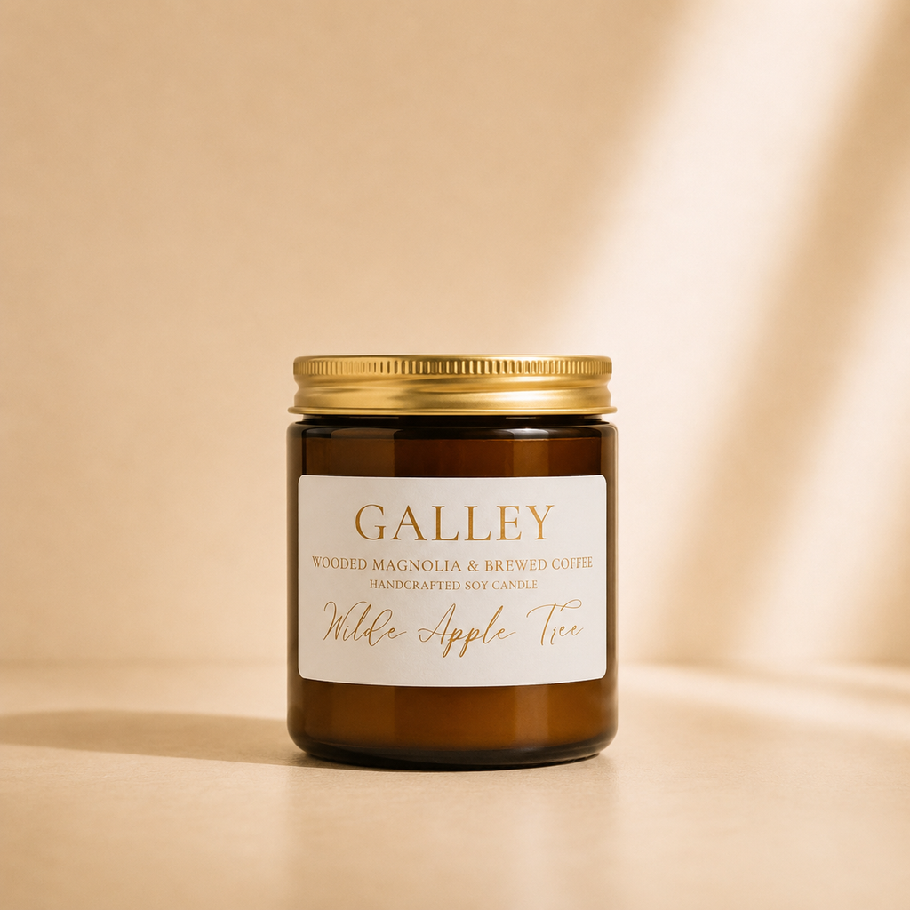Wilde Apple Tree Galley medium soy candle in amber glass jar with gold lid in warm studio light, wooded magnolia and brewed coffee handcrafted soy candle made in Australia
