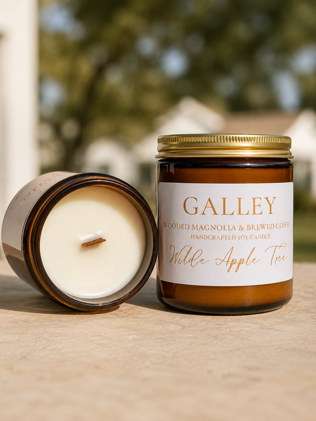 Wilde Apple Tree Galley medium soy candle in amber glass jar with lid removed showing natural wooden wick outdoors, wooded magnolia and brewed coffee scent, handcrafted in Australia