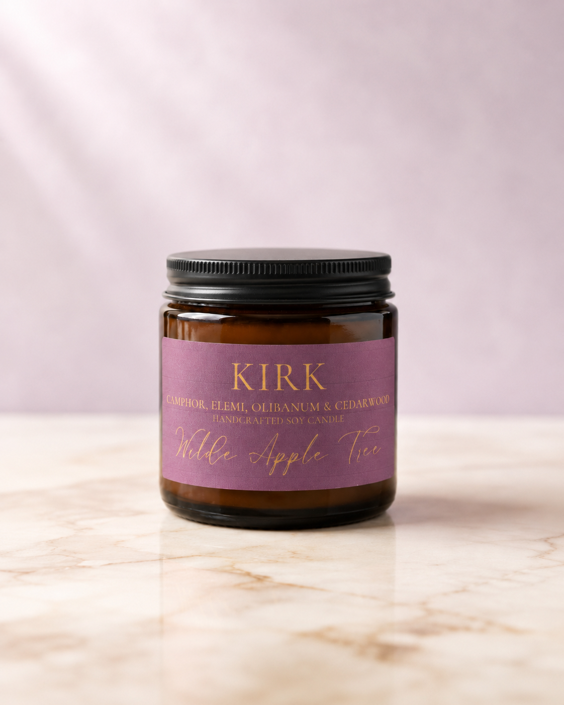 Wilde Apple Tree Kirk mini soy candle in amber glass jar with black lid and plum label on marble surface, camphor elemi olibanum and cedarwood scented handcrafted soy candle made in Australia