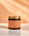 Wilde Apple Tree Sundara mini soy candle in amber glass jar with gold lid and terracotta label on marble surface, blood orange geranium wilfordii and sandalwood scented handcrafted soy candle made in Australia