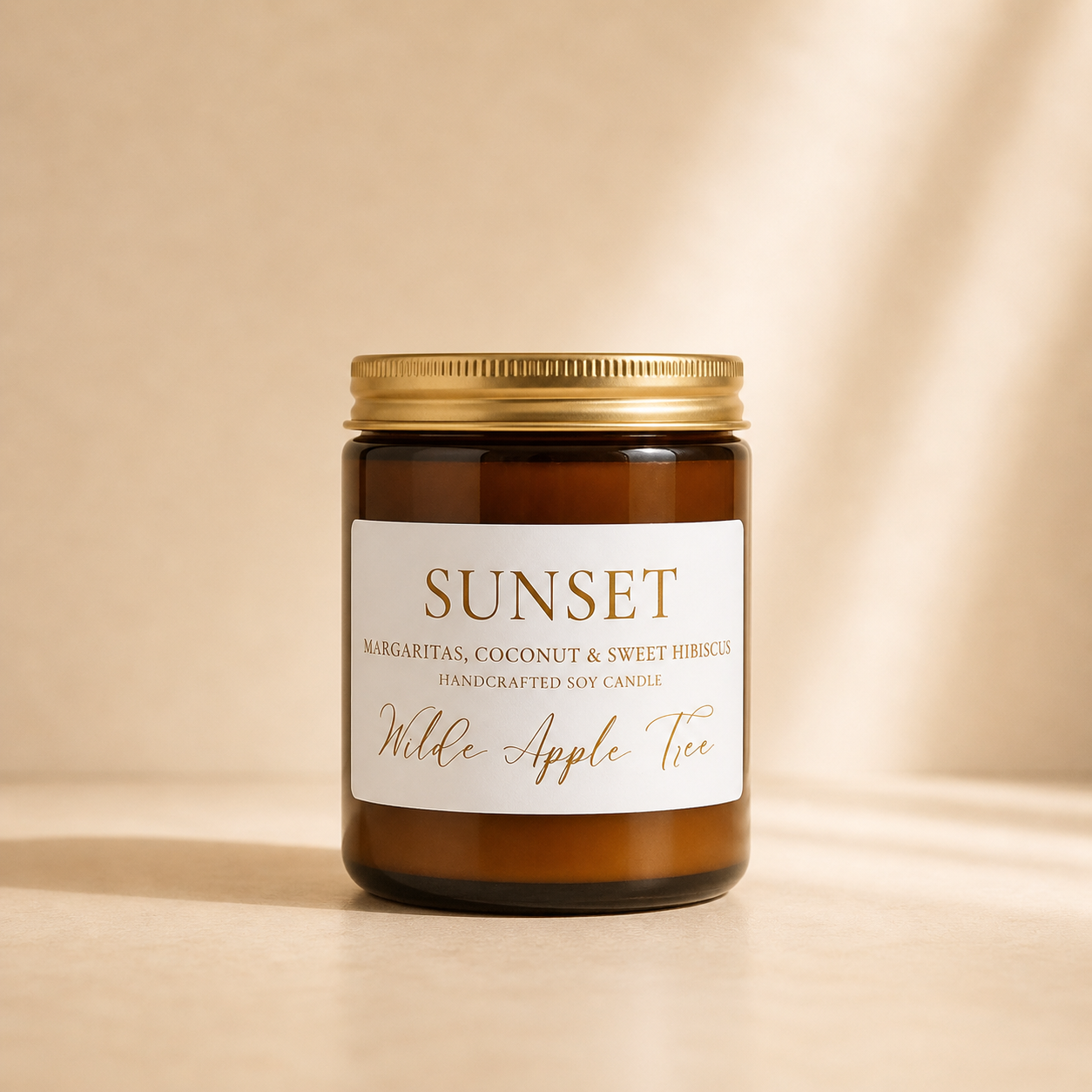 Wilde Apple Tree Sunset medium soy candle in amber glass jar with gold lid in warm studio light, margarita coconut and sweet hibiscus handcrafted soy candle made in Australia