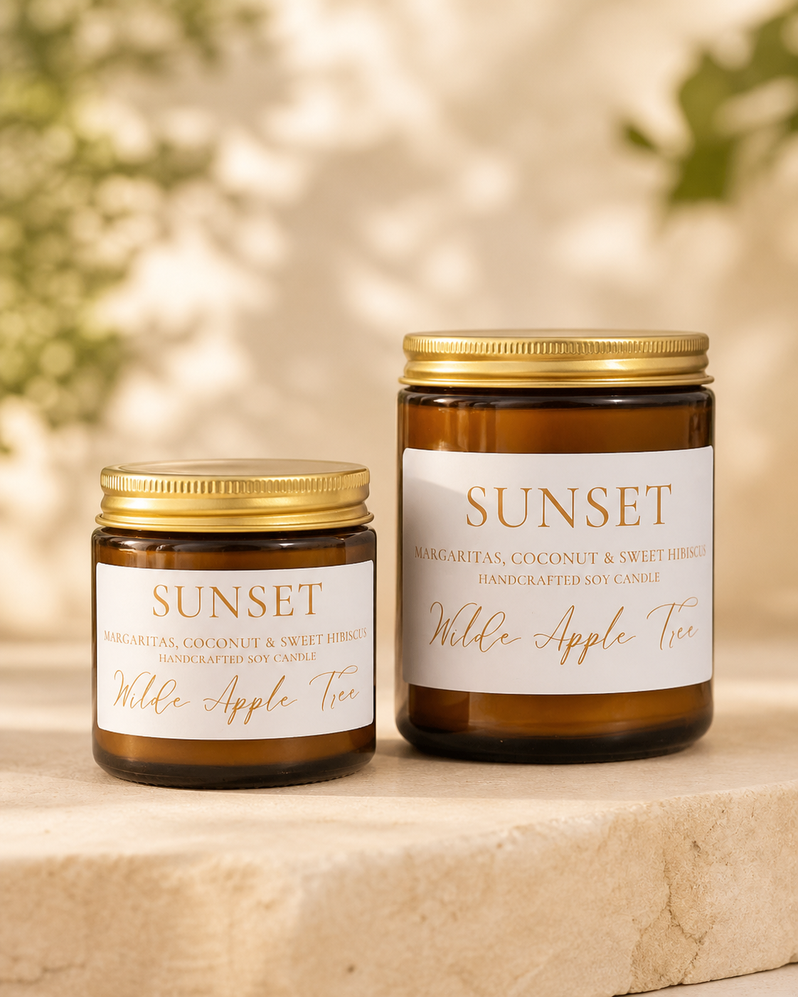 Wilde Apple Tree Sunset handcrafted soy candles in mini and medium amber glass jars displayed on stone plinth, margarita coconut and sweet hibiscus scent, made in Australia